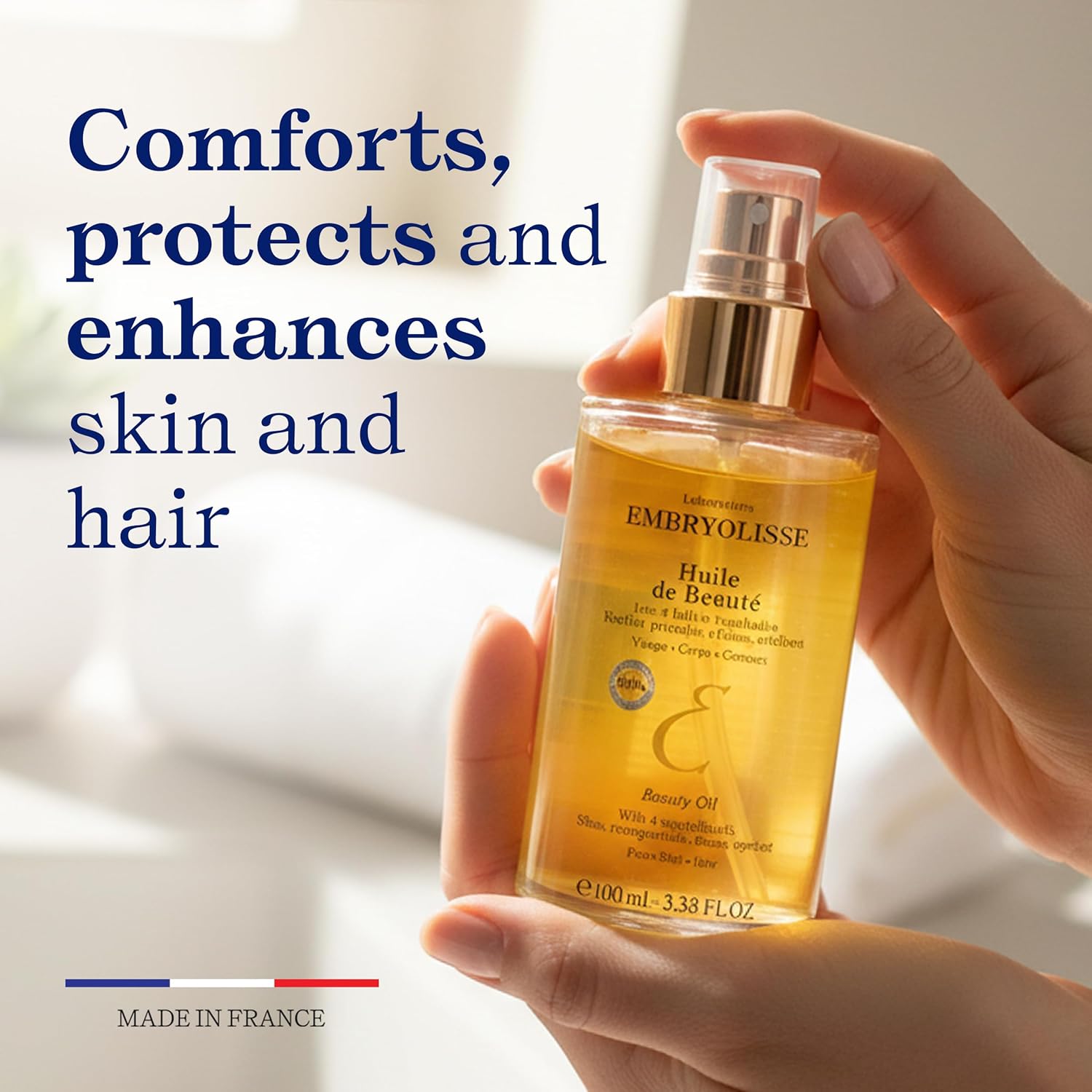 Woman hands holding Beauty Oil bottle by Embryolisse showing the skicnare product benefits