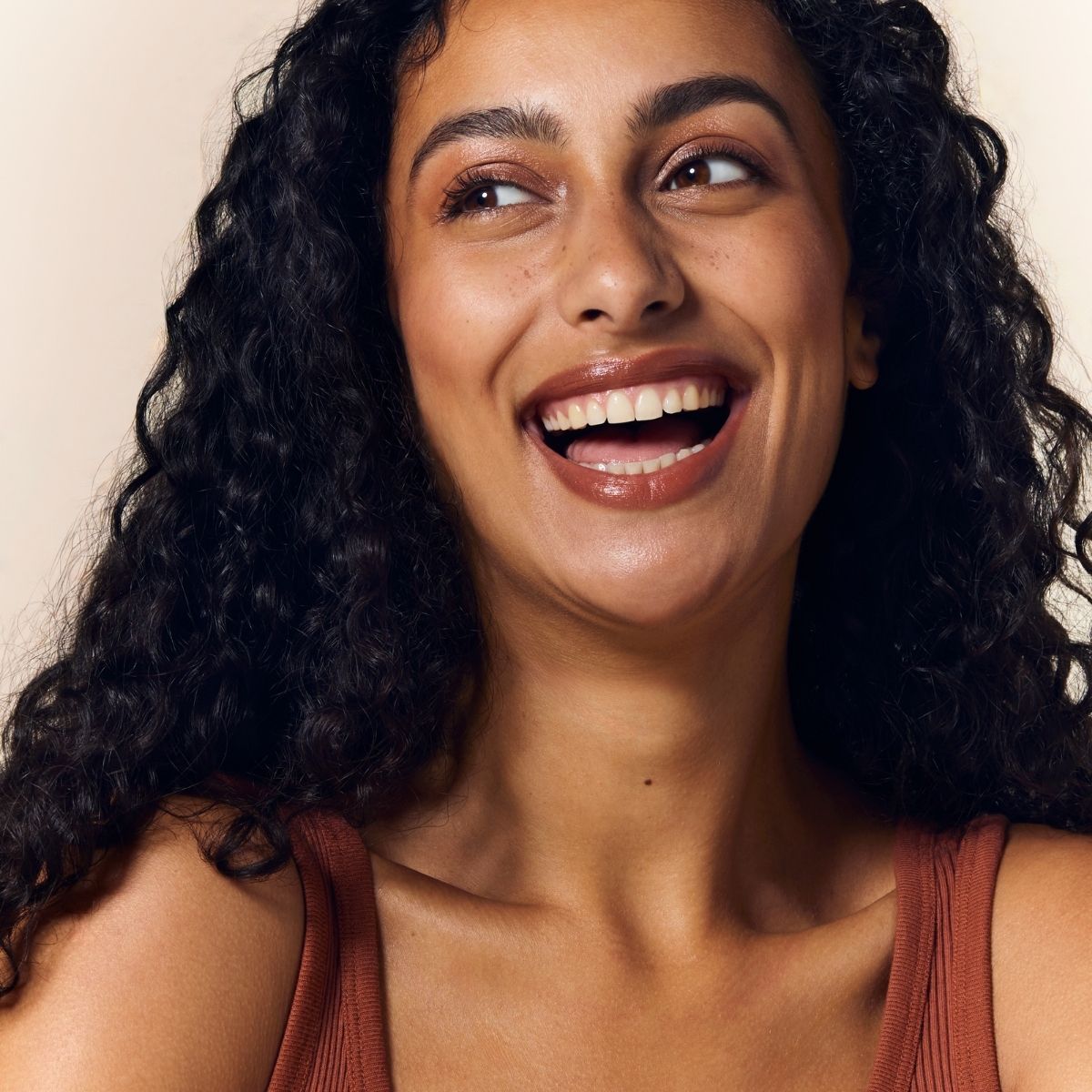 Model wearing Embryolisse Artist Secret Color Balm 3-in-1 Stick Mocha with a natural, warm makeup finish