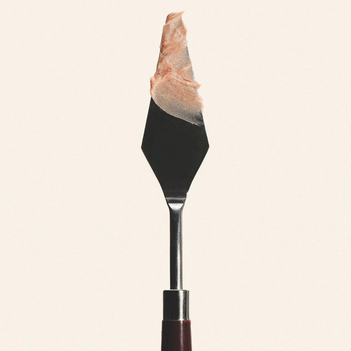 Champagne Color Balm texture on a palette knife, showing the creamy, pearly highlighter formula